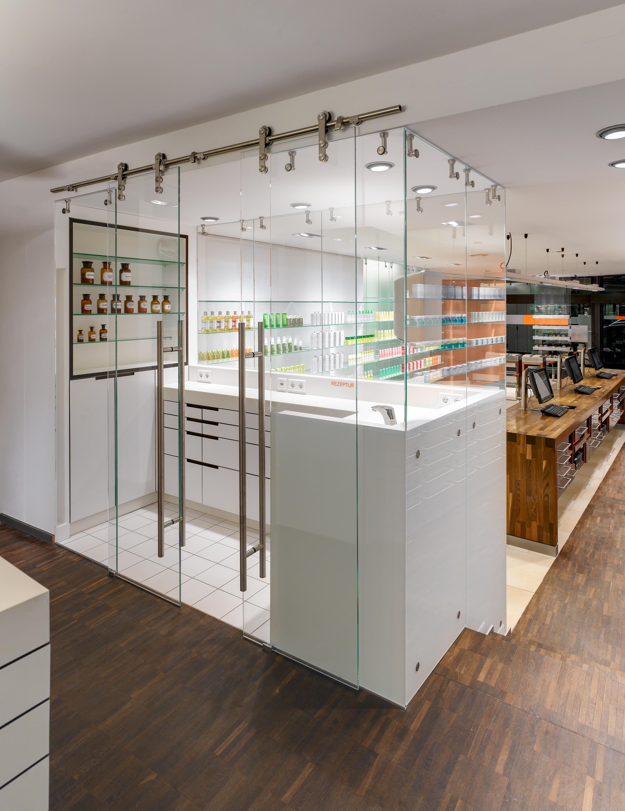 Verglaste Rezeptur mit Glasschiebetüren und sichtbaren Edelstahlbeschlägen