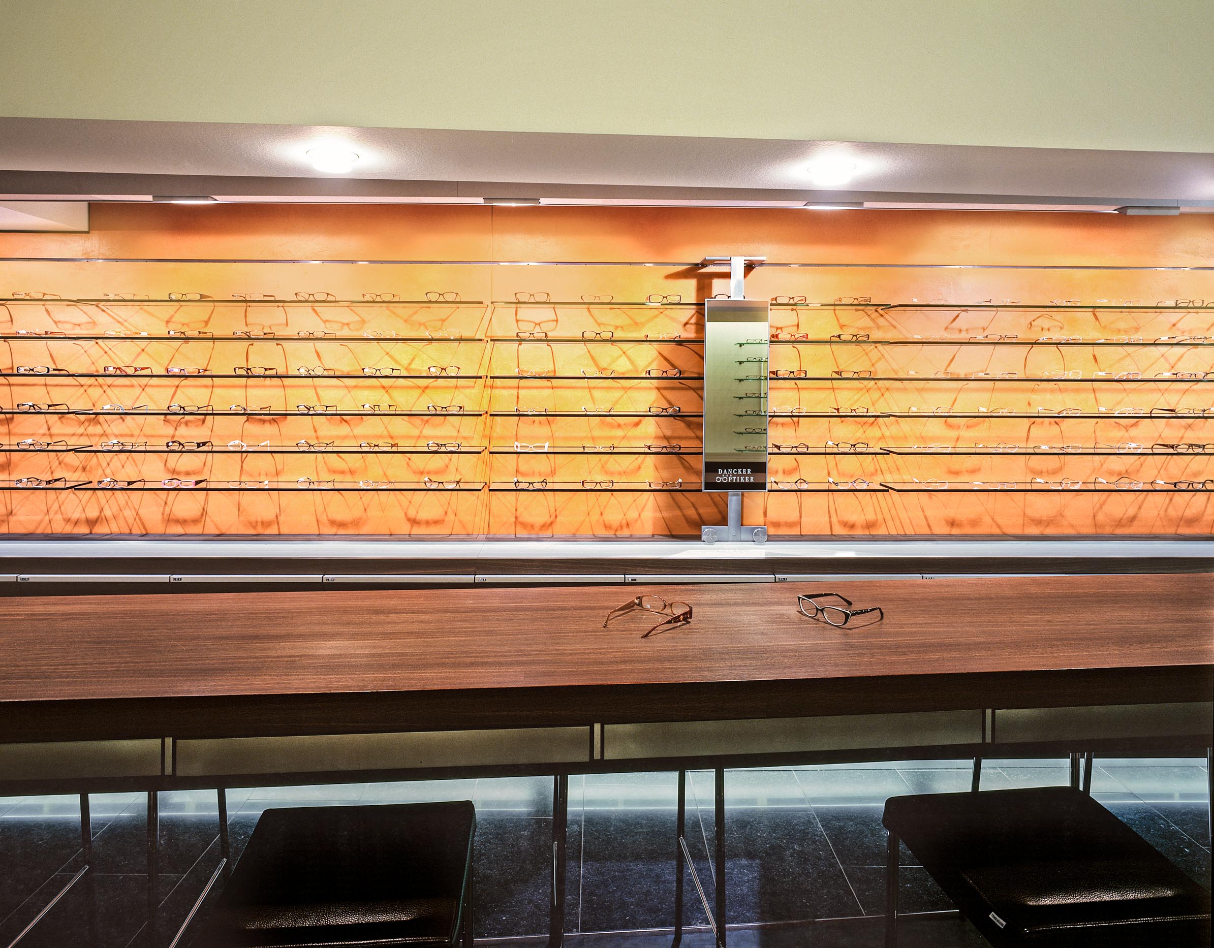 Orangefarbene Brillenwand mit Beratungstheke