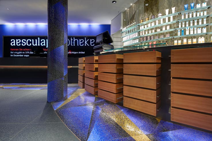 Aesculap Apotheke, Offizin, runder HV-Tisch, virtuelle Sichtwahl, Mosaik Gold und Blau